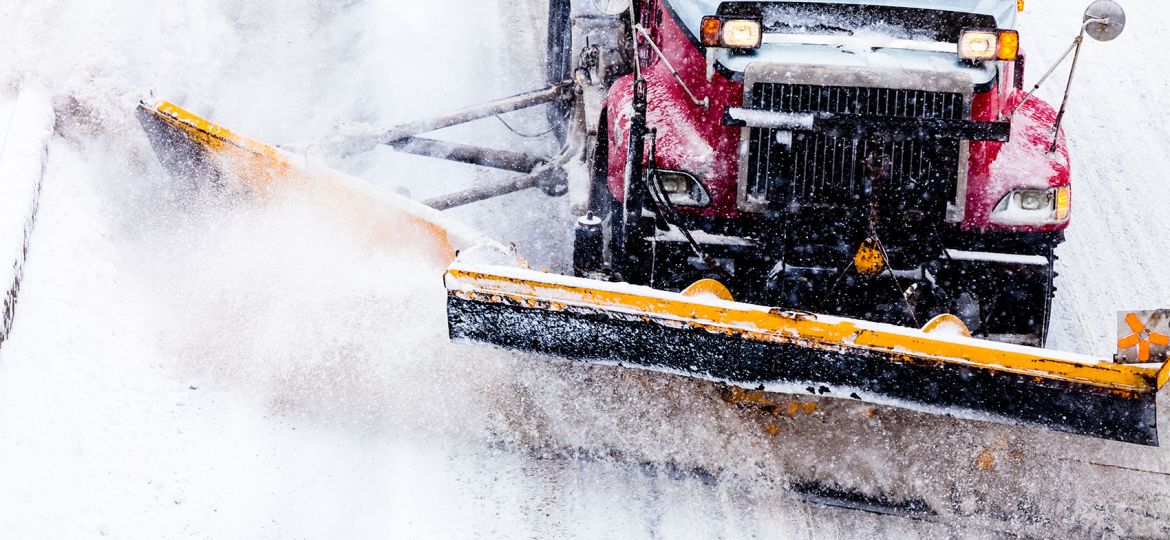 Snowplow Truck Removing the Snow from the Highway during a Snowstorm