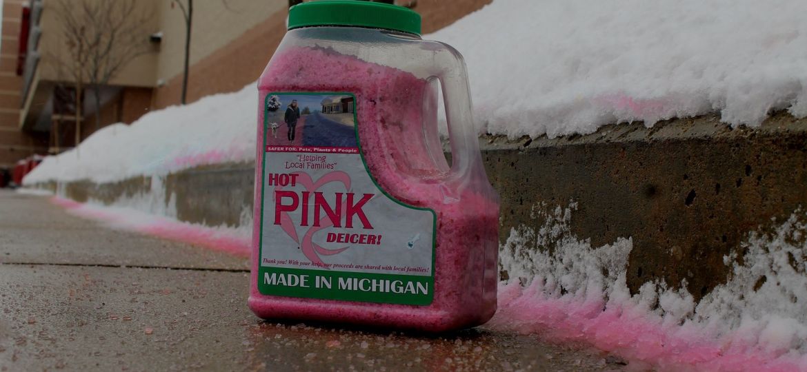 A bottle of Hot Pink Deicer on a sidewalk