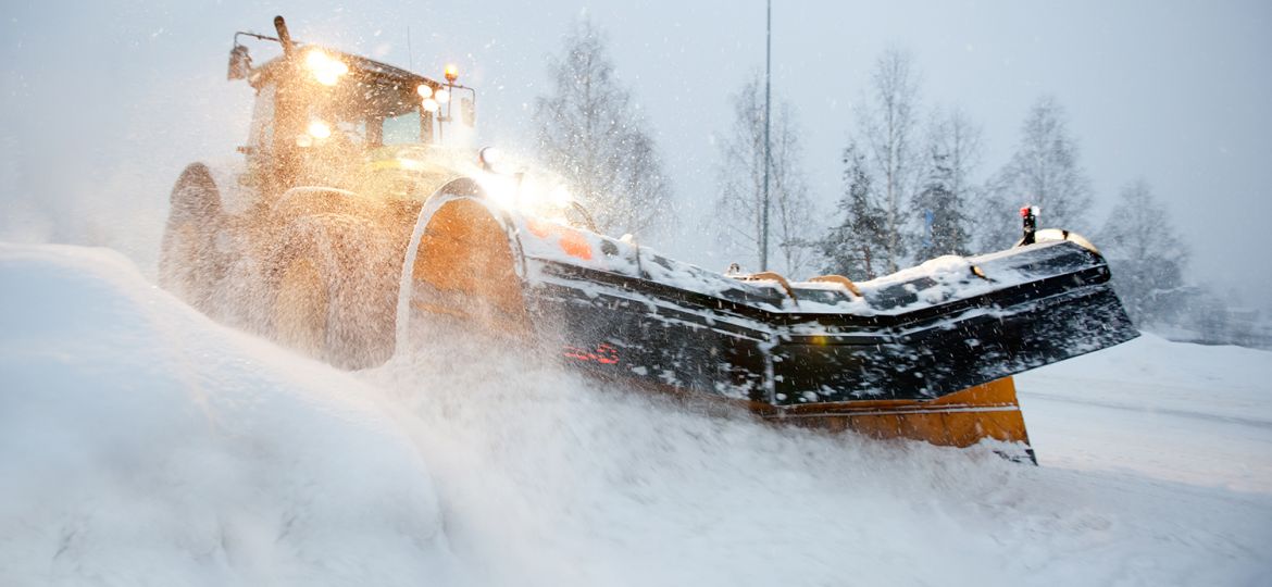 Snow plow in midwest winter pushing snow in blizzard