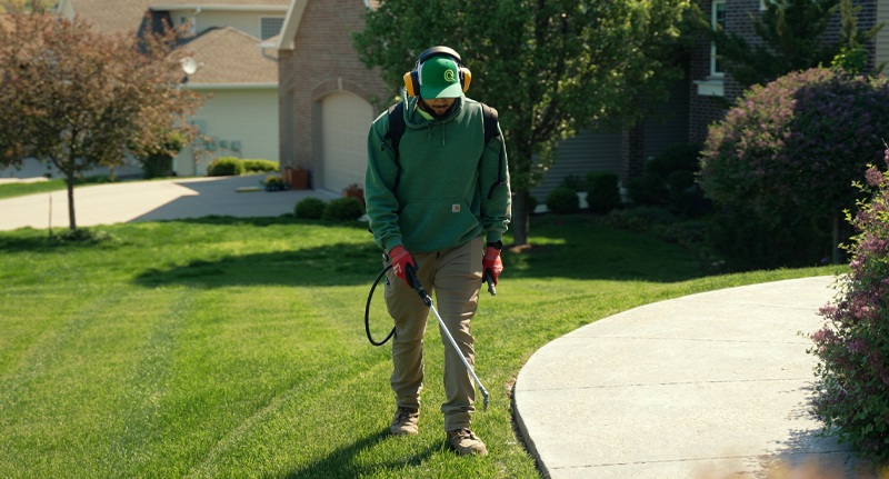 person spraying grass